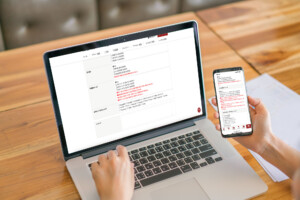 Business woman hand with Financial charts and mobile phone over laptop on the table